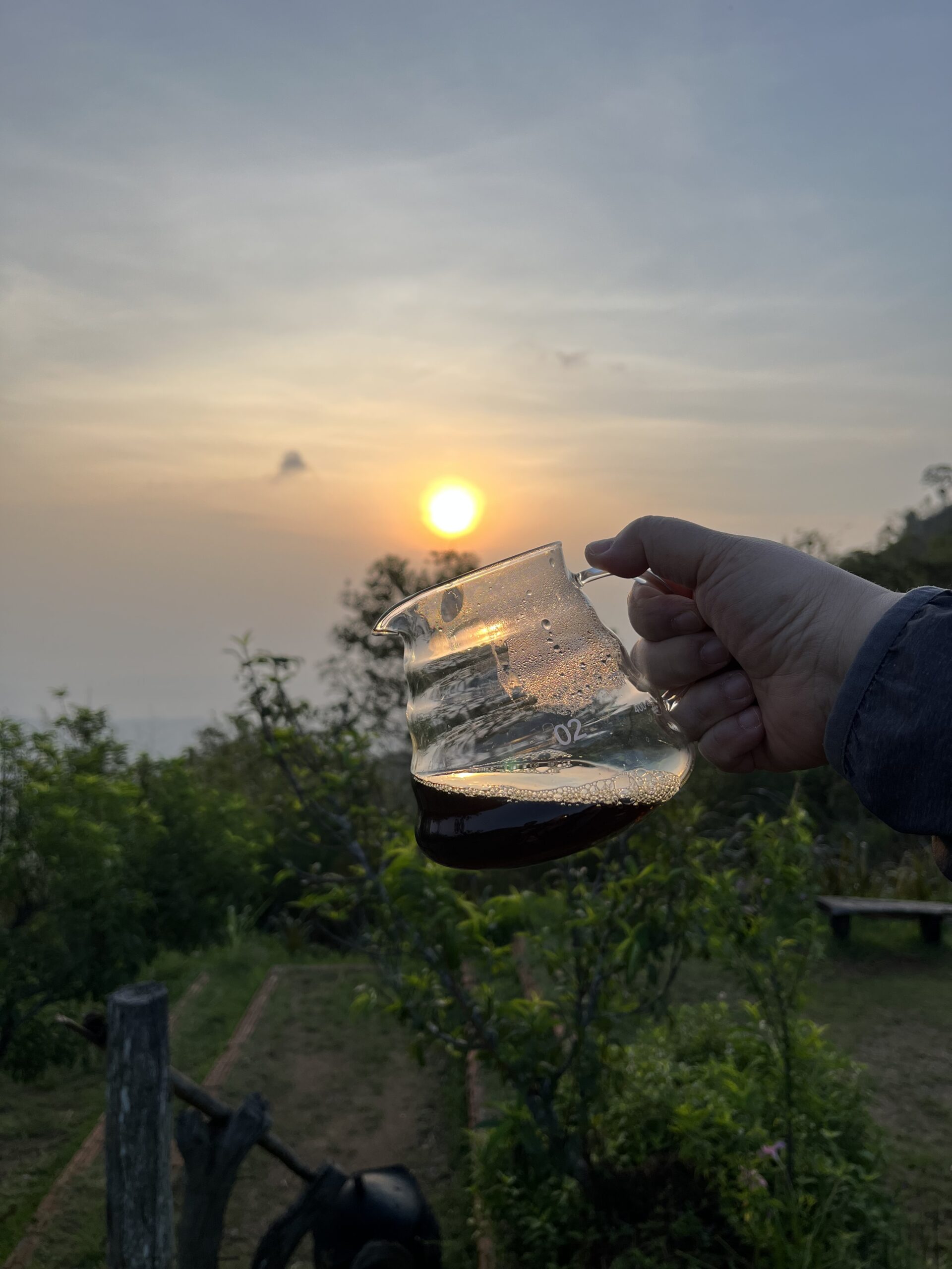 Pouring freshly brewed specialty coffee for a friend during a golden sunset in Mae Hong Son, capturing the sincerity and joy of sharing coffee.